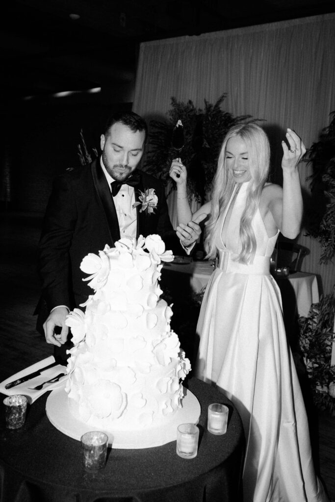 Bride and groom in front of their wedding cake at Bridgeport Art Center.