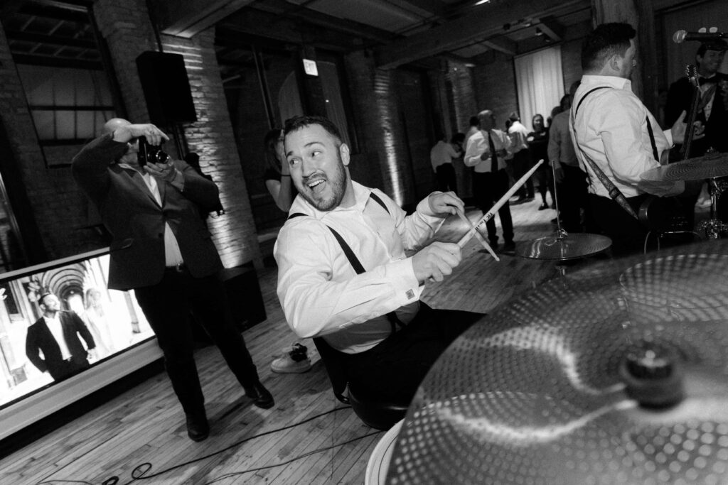 Groom playing drums in the Skyline Loft at Bridgeport Art Center.