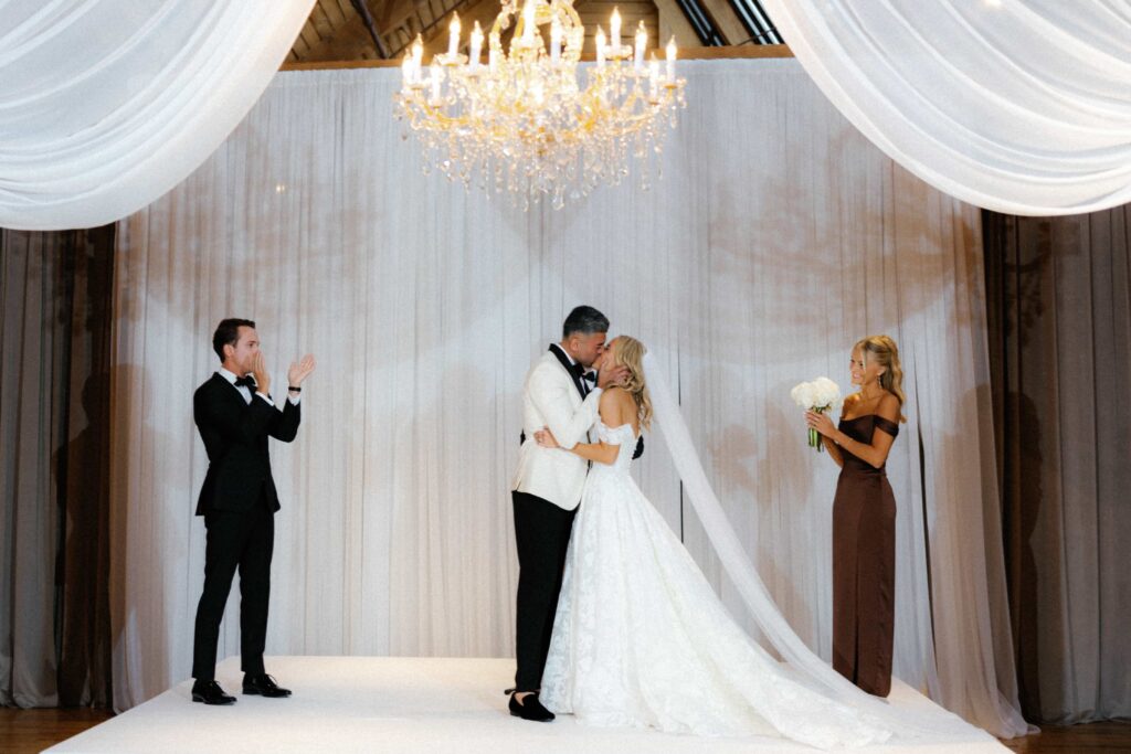 Bride and groom share their first kiss during the ceremony in the Skyline Loft at the Bridgeport Art Center.