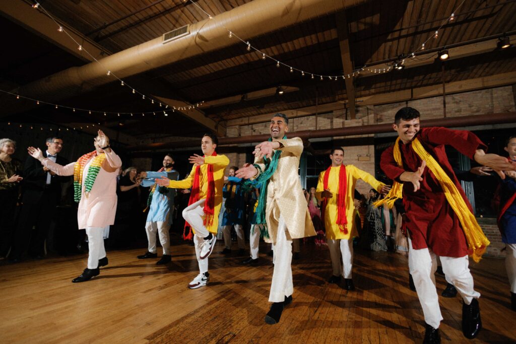 Groom and groomsmen take part in a traditional dance during the wedding reception at the Bridgeport Art Center.