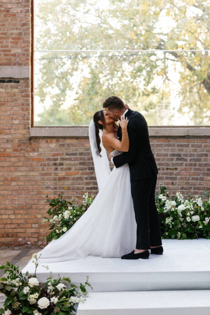 The bride and groom have their first kiss at their Bridgeport Art Center Chicago wedding.