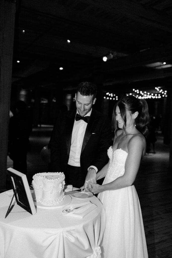 Bride and groom cut the wedding cake at their reception in Bridgeport Art Center.