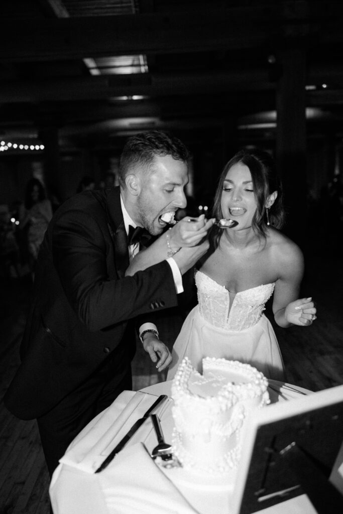 Bride and groom cut the wedding cake at their reception in Bridgeport Art Center.