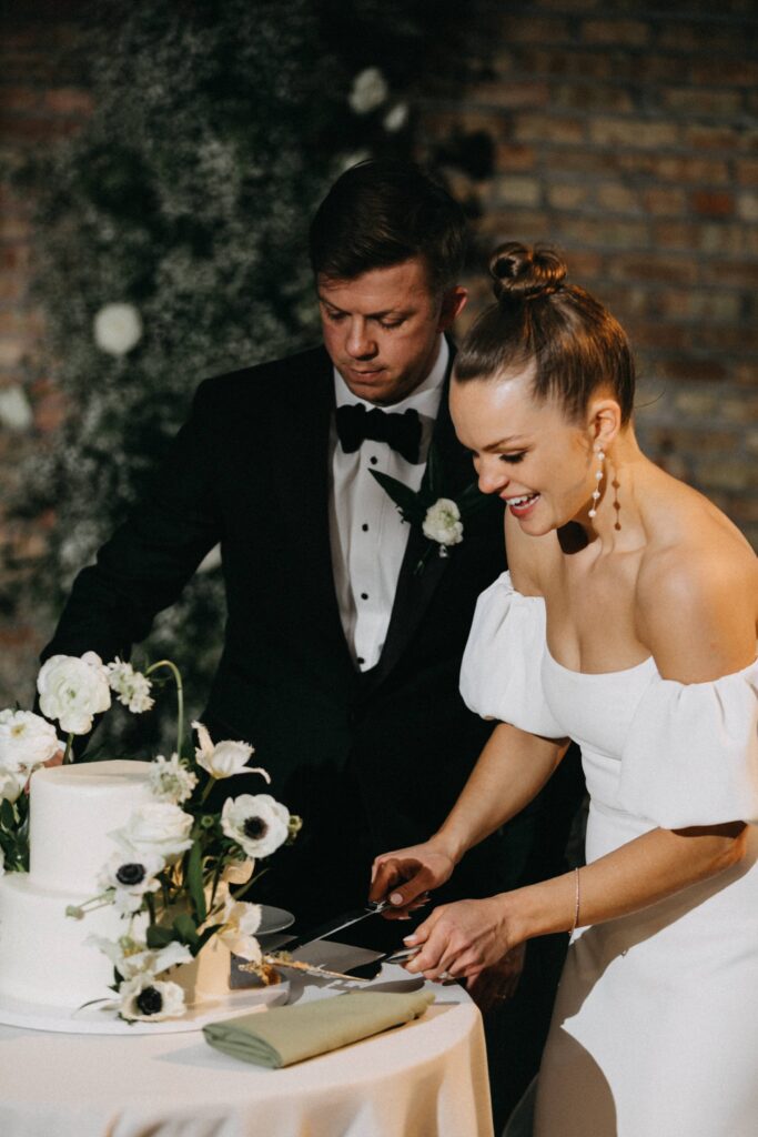 Bride and groom cut the cake during their wedding reception.