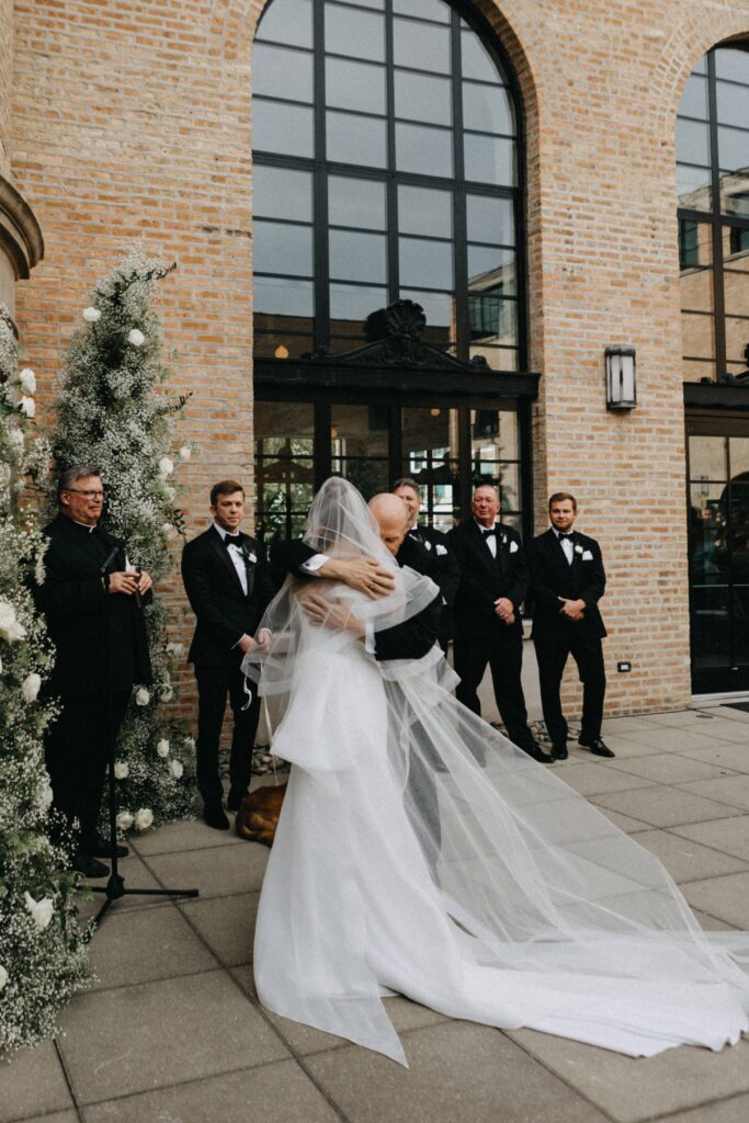 Bride and her father embrace as he walks her down the aisle at Revel Space.