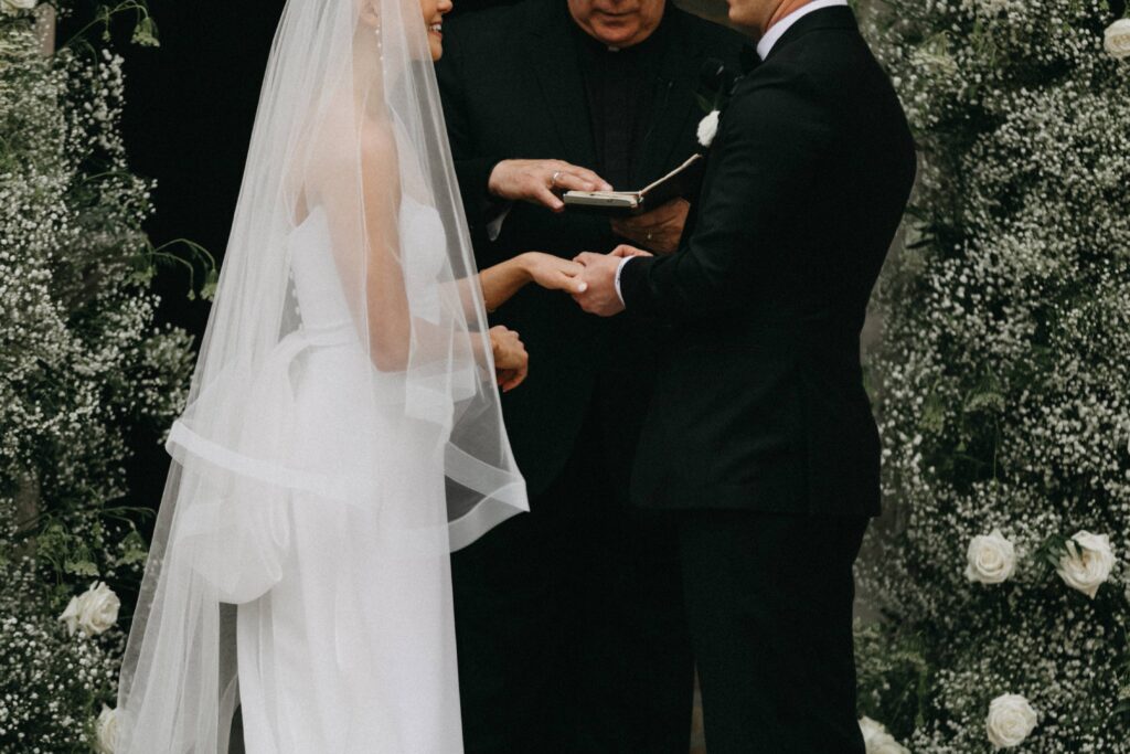 The bride and groom hold hands during the ceremony as they exchange vows.