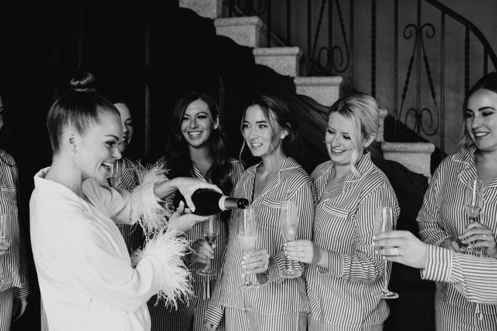 Bride and bridesmaids sharing champagne as they get ready in the Revel Space suites.