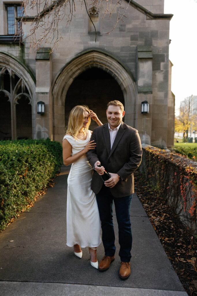 Popping champagne to celebrate their engagement session at the University of Chicago.