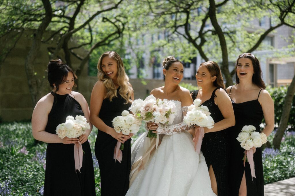 Bride and bridesmaids laugh with their bouquets in downtown Chicago