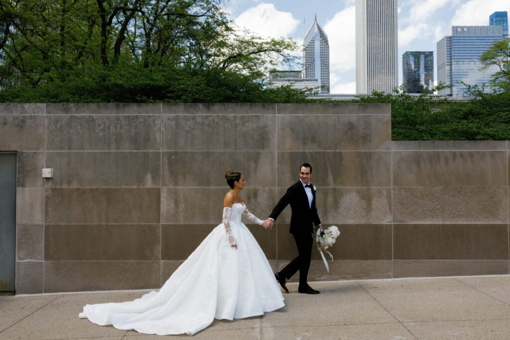 Wedding couple hold hands and walk through downtown Chicago