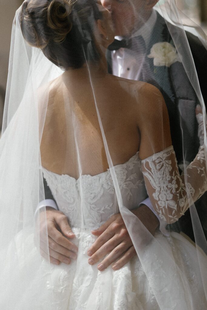 Bride and groom kiss under veil on their wedding day in Chicago