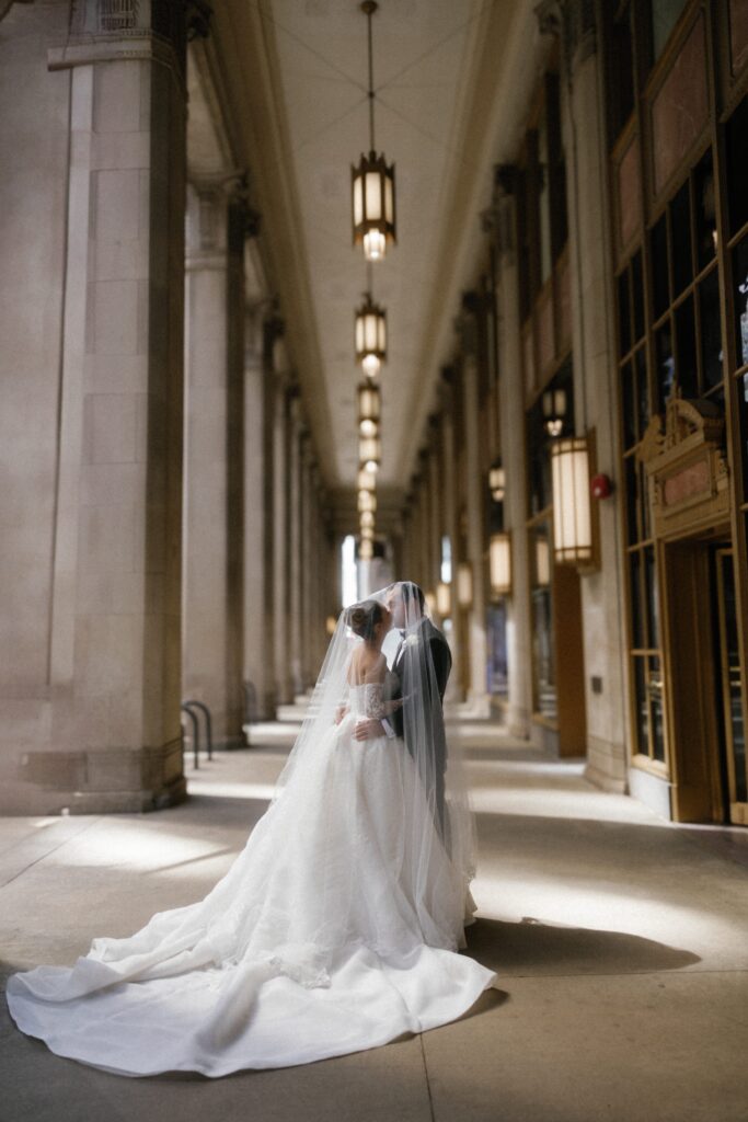 Wedding couple kiss under veil in downtown Chicago