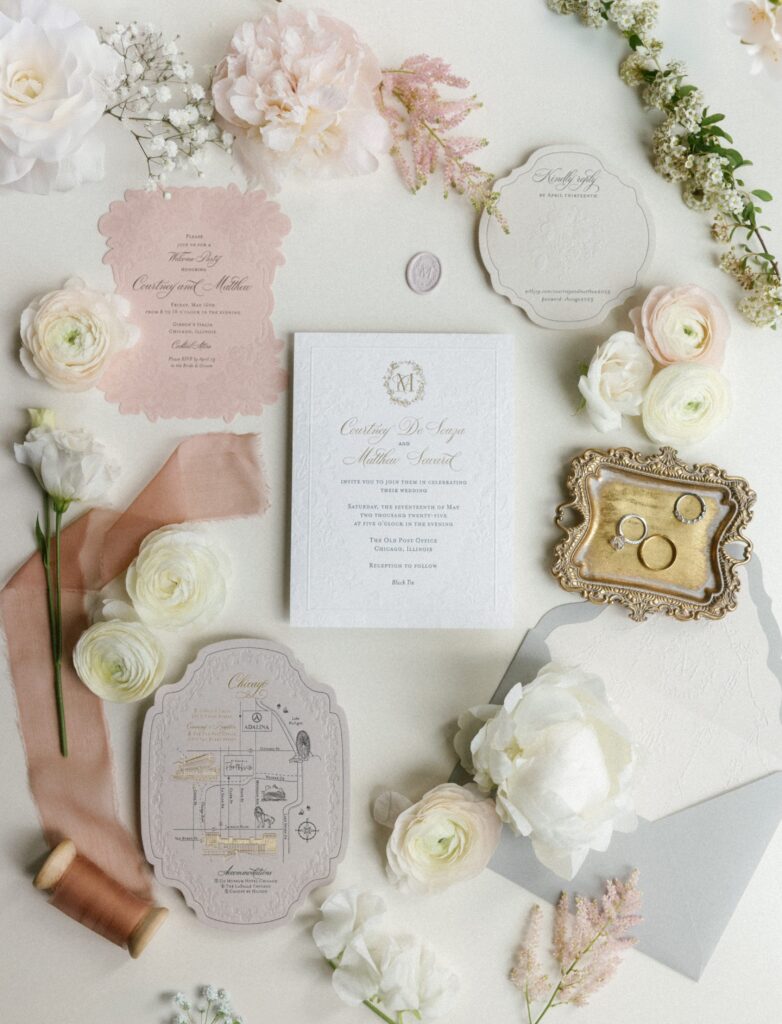 Wedding detail flatlay with rings, flowers and invitation suite at The Old Post Office