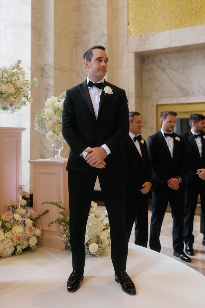 Groom sees bride walking up the aisle at wedding ceremony in Chicago