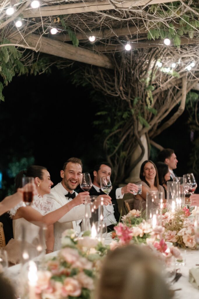 Bride and groom cheers with their guests at the Orchard Pergola in Ojai